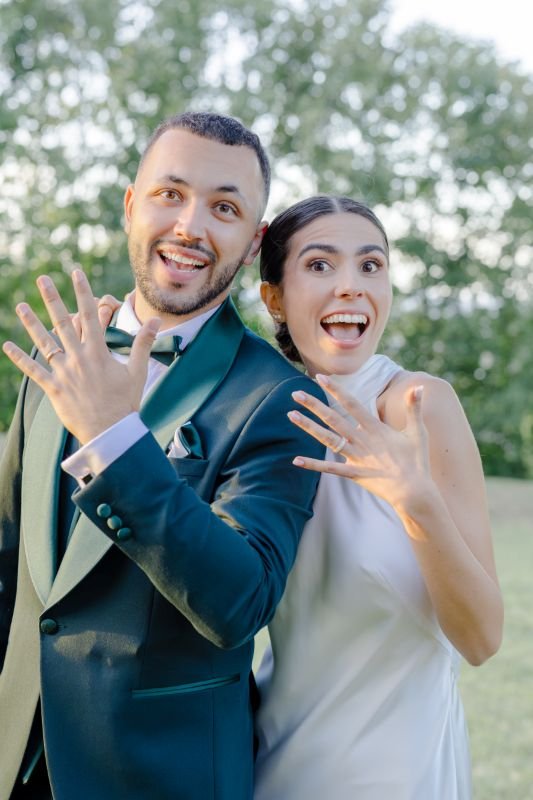 Les mariés montrent leurs alliances avec de grands sourires