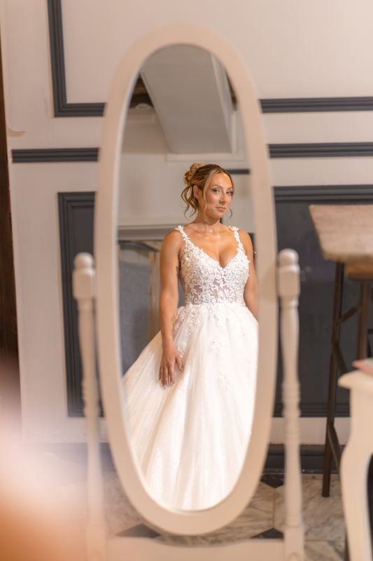 Reflet de la mariée en robe de dentelle dans un grand miroir ovale